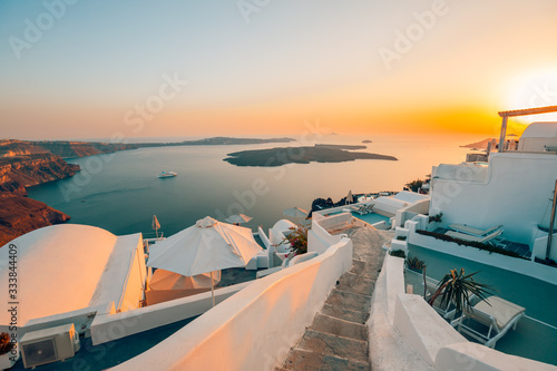 Fototapeta Naklejka Na Ścianę i Meble -  White architecture over street and sea view. Tranquil summer travel and vacation. Beautiful sunset on Santorini island, Greece.