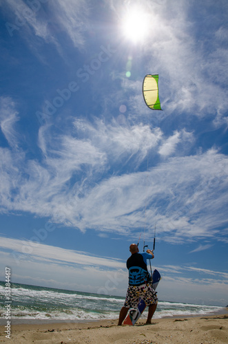 A young man kite surfer ready for kite surfing rides in blue sea.Kite surfing Kite boarding, adventure surface water sport, combination of the , windsurfing and surfing,  into one extreme sport.