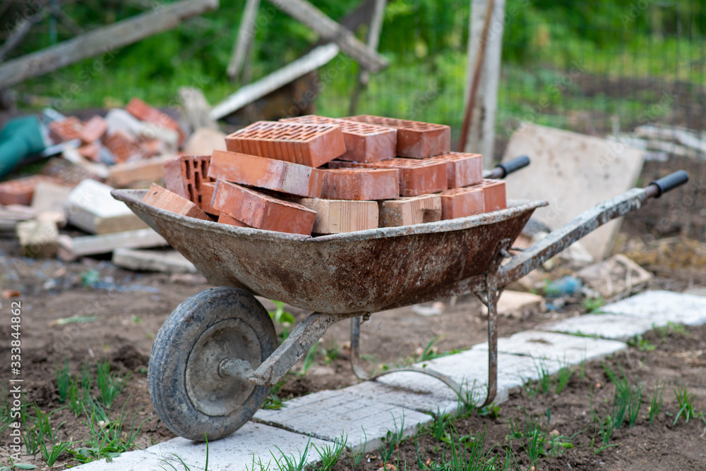 Close up picture of construction site. Bricks in a wheelbarrow Close up picture of construction site. Bricks in a wheelbarrow