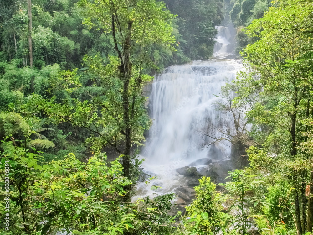 view of silky waterfall flowing around with green forest background, Sirithan Waterfall, Doi Inthanon National Park, Chiang Mai, northern of Thailand.