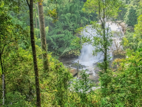 view of silky waterfall flowing around with green forest background, Sirithan Waterfall, Doi Inthanon National Park, Chiang Mai, northern of Thailand. photo