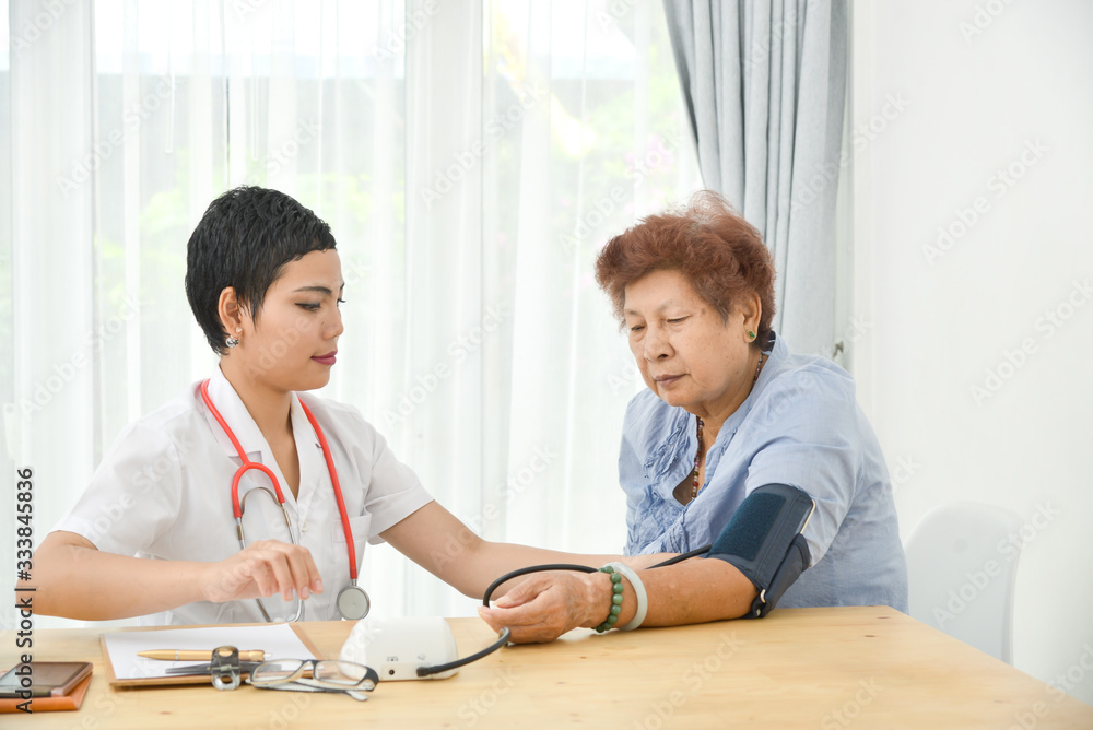Asian doctor checking up her patient old woman in office. Asian doctor checking up her patient old woman in office.