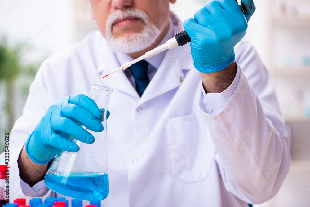 Old male chemist working in the lab Old male chemist working in the lab