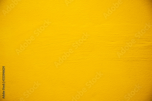 Blurred Yellow stucco wall background. Yellow painted cement wall texture.