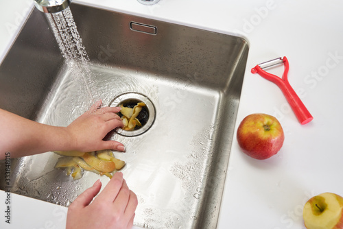 Food waste disposer machine in sink in modern kitchen photo