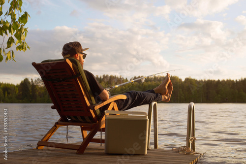 Canvas Print Mature man fishing from gangway