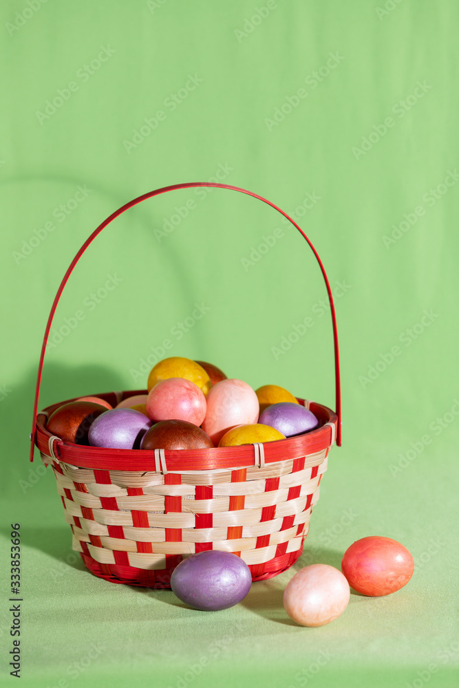 Easter eggs in basket isolated on green