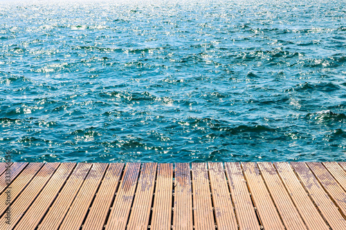 Sea waves with wooden planks dock.