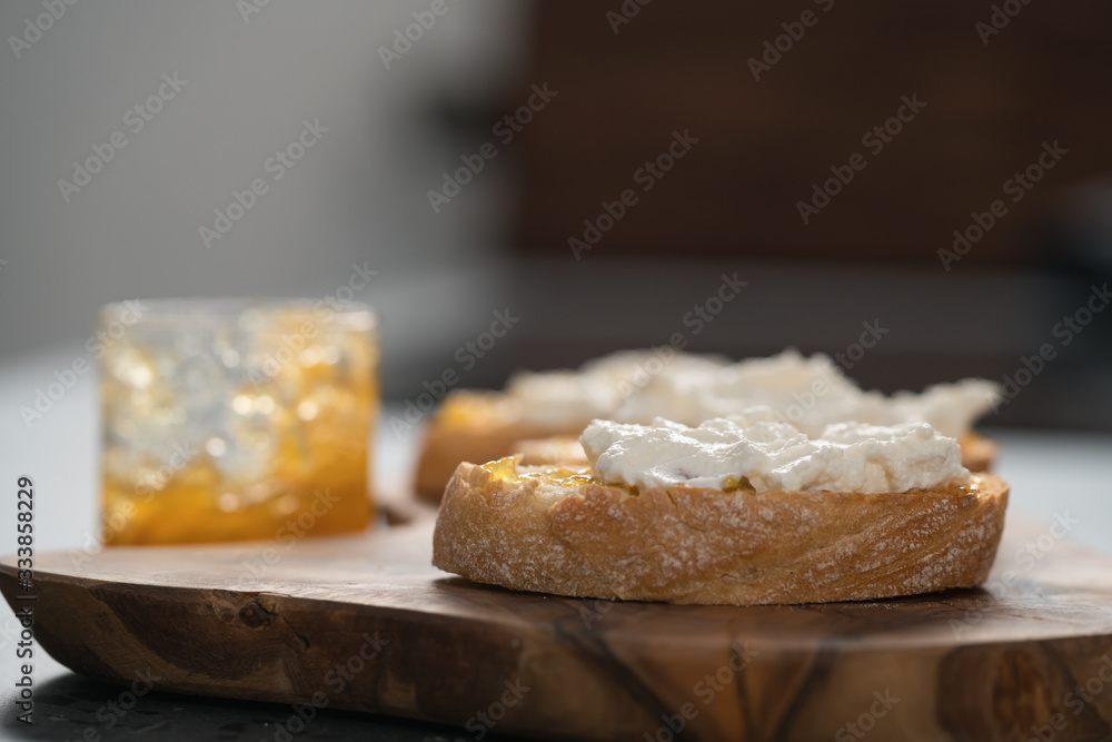 Ciabatta slices with orange marmalade and ricotta on olive board Ciabatta slices with orange marmalade and ricotta on olive board