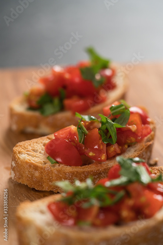 bruschetta with cherry tomatoes and spinach leaves on olive board