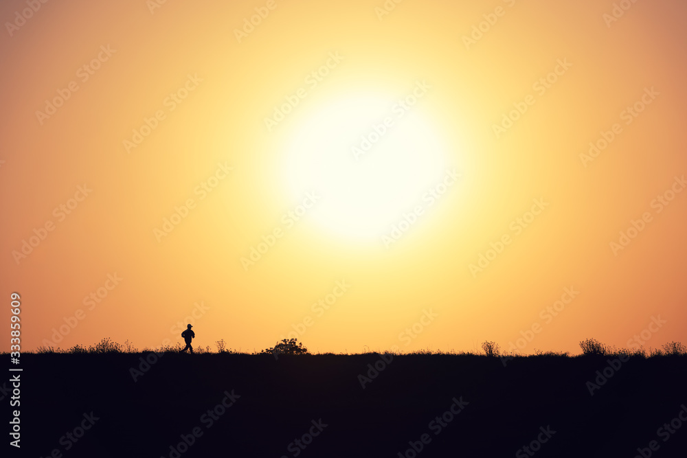 夕日をバックに走るランナー