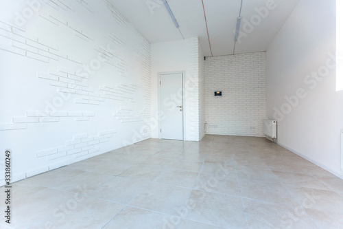 Light room with window and heating battery. Wall is of white plaster, has several outlets. Professional installation of electrical sockets, wires and switches. Connecting the light in flat or office © Angelov