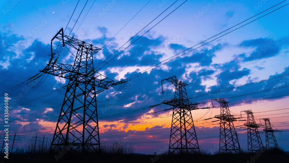Time Lapse of Electrical Grid and Transmission Line at Dusk. Electricity Pylons Against Sky at Sunset. Clouds Moving Across Sky. Landscape of Five High Voltage Towers. Ecology concept