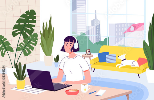 Young woman freelancer works remotely from her apartment. The concept of distant work during the quarantine and isolation of coronavirus