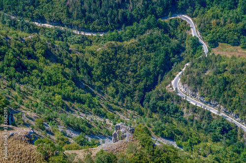 A winding mountain road through the woods in extreme high altitude.