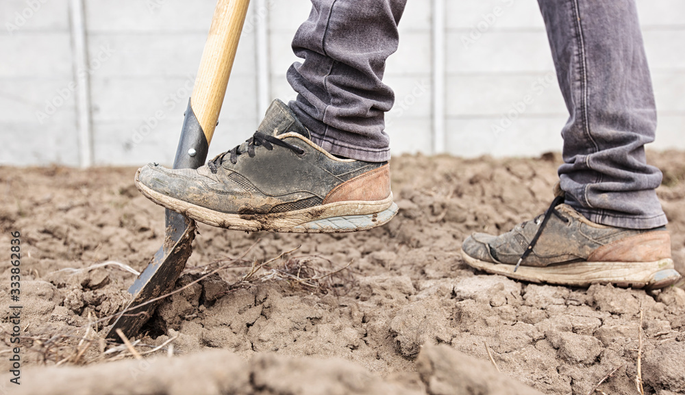 The man is digging the soil ground on his country house The man is digging the soil ground on his country house