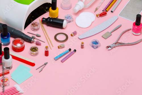 A set of cosmetic tools for manicure and pedicure on a white background. Gel polishes, nail files, manicure scissors, pusher and clippers top view. Composition for card with a place for text