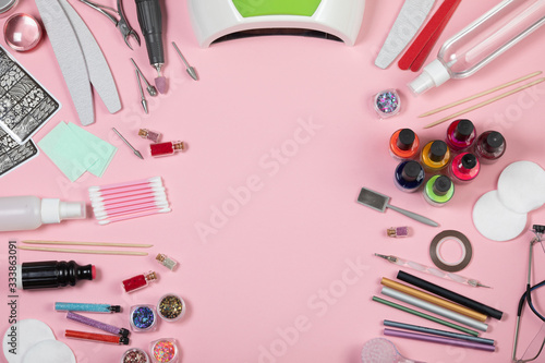 A set of cosmetic tools for manicure and pedicure on a white background. Gel polishes, nail files, manicure scissors, pusher and clippers top view. Composition for card with a place for text