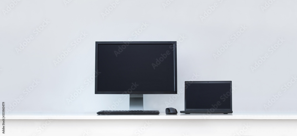 Clean white desk with computer screen and laptop. Clean white desk with computer screen and laptop.