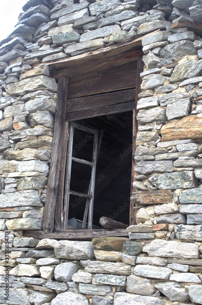 particolare facciata in pietra a vista di antico fabbricato rurale