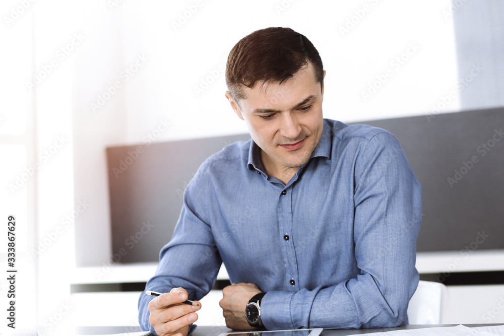 Businessman working with tablet computer in modern office. Headshot of male entrepreneur or company director at workplace. Business concept Businessman working with tablet computer in modern office. Headshot of male entrepreneur or company director at workplace. Business concept