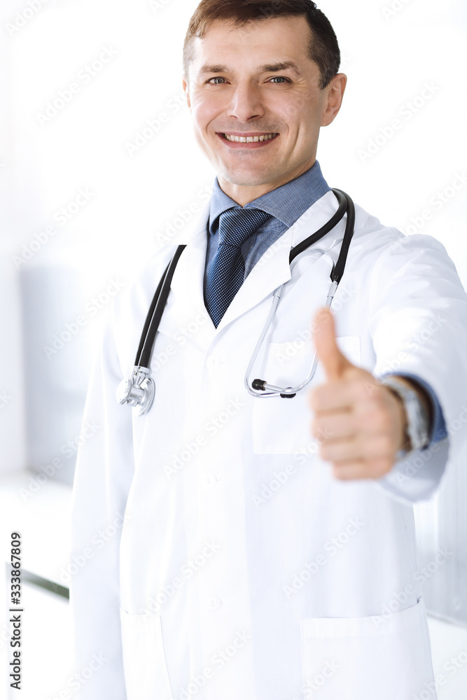 Doctor man cheerful smiling at camera, thumbs up. Perfect medical service in clinic. Happy future in medicine and healthcare Doctor man cheerful smiling at camera, thumbs up. Perfect medical service in clinic. Happy future in medicine and healthcare