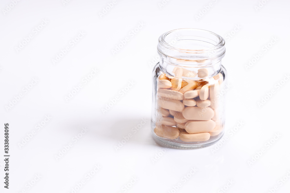 Vitamin tablets in glass bottle on white background Vitamin tablets in glass bottle on white background