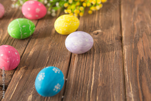 Colorful easter eggs with flowers on a old wooden surface