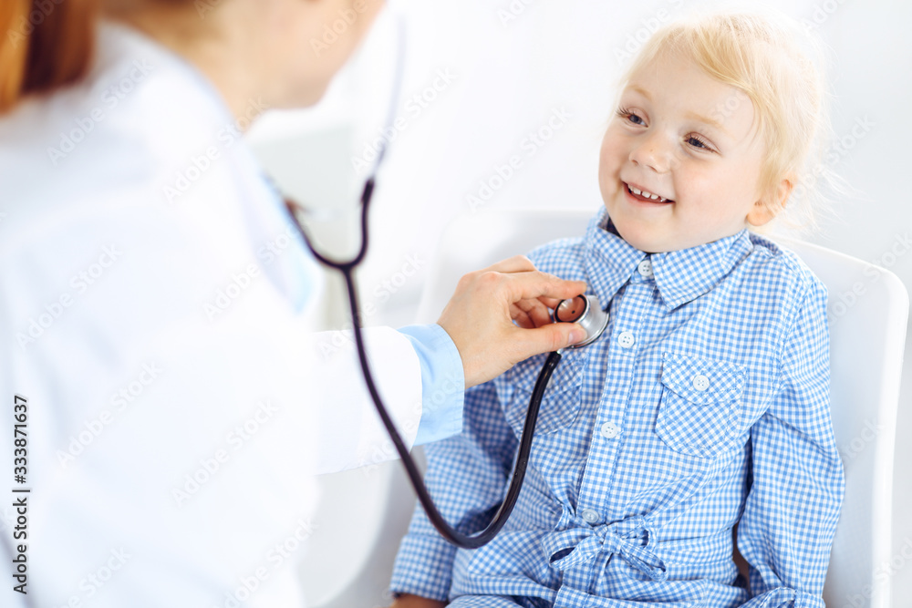 Happy smiling child patient at usual medical inspection. Doctor and patient in clinic. Medicine, healthcare concepts Happy smiling child patient at usual medical inspection. Doctor and patient in clinic. Medicine, healthcare concepts