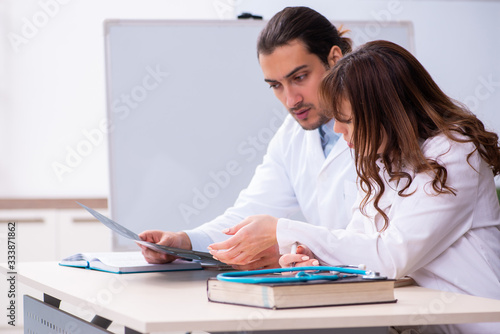 Young male doctor radiologist and female student in the classroo photo