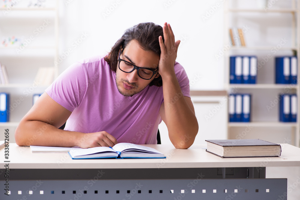 Young male student preparing for exams at classroom Young male student preparing for exams at classroom