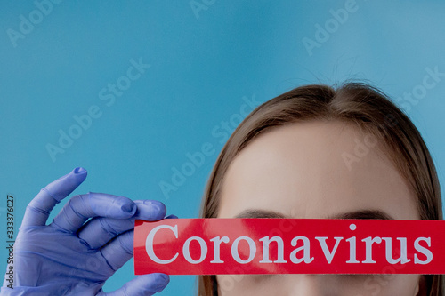 Doctor woman pointing to red paper with mesaage Coronavirus on blue background. World Health Organization WHO introduced new official name for Coronavirus disease named COVID-19 photo