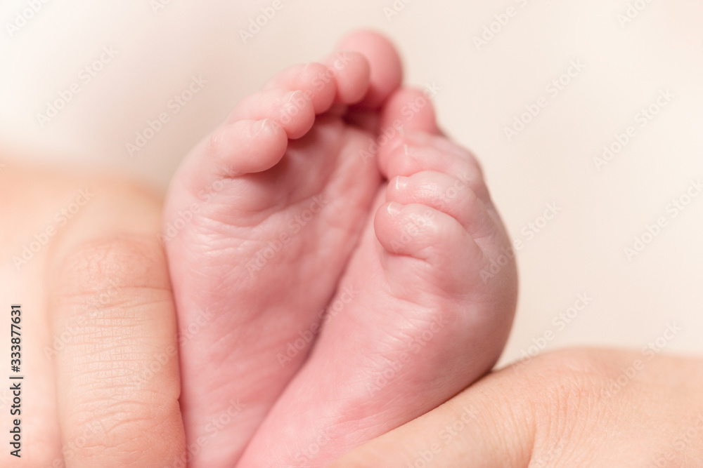 Mother's hands with tiny baby legs, closeup. Mom and her Child. Happy Family concept. Beautiful conceptual image of Maternity. Selective focus. Mother's hands with tiny baby legs, closeup. Mom and her Child. Happy Family concept. Beautiful conceptual image of Maternity. Selective focus.