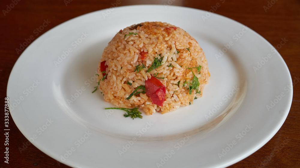 Spicy fried rice with vegetables on a white plate, dinner in a restaurant. Spicy fried rice with vegetables on a white plate, dinner in a restaurant.