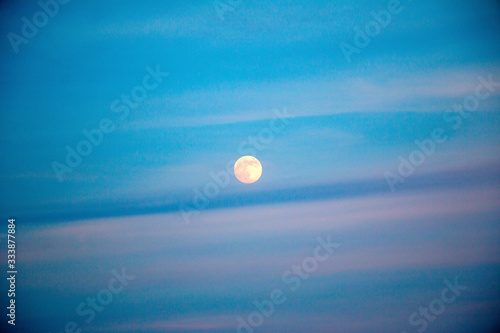 full moon in evening sky with clouds