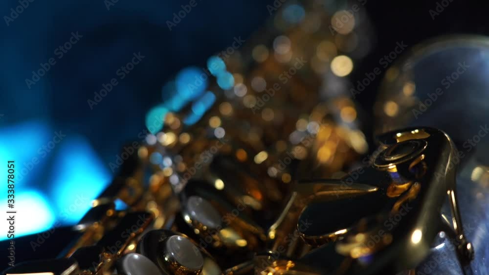 Golden shiny alto saxophone on black background with blue smoke Golden shiny alto saxophone on black background with blue smoke