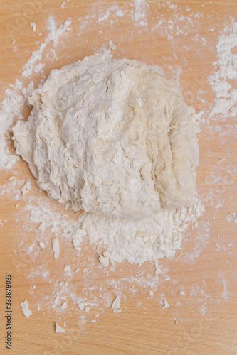 Prepared kneaded dough on a wooden table at home