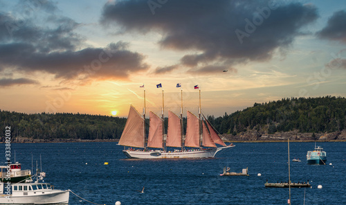 фотографія A four masted schooner touring sightseers through a blue harbor off Bar Harbor,