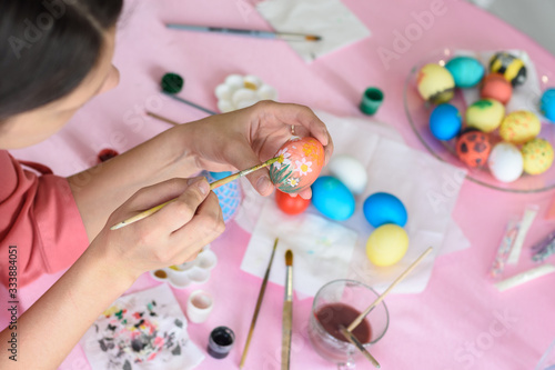 Girl paints chicken eggs for Easter