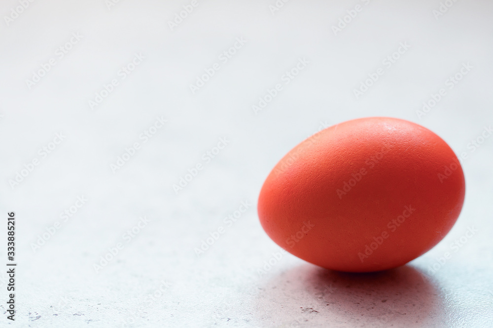 Red easter egg on grey concrete table. Front view. Selective focus. Easter decoration. Red easter egg on grey concrete table. Front view. Selective focus. Easter decoration.