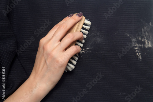 Close-up of the process of clothes cleaning. Woman hand with clothes brush and cloth