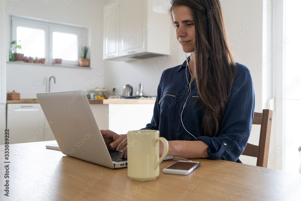 Smart working, young woman working from home on her laptop computer Smart working, young woman working from home on her laptop computer
