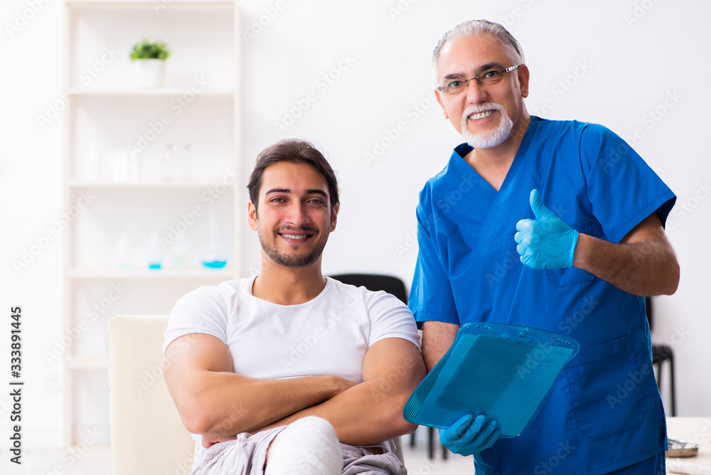 Obraz premium Leg injured man visiting old doctor in first aid concept