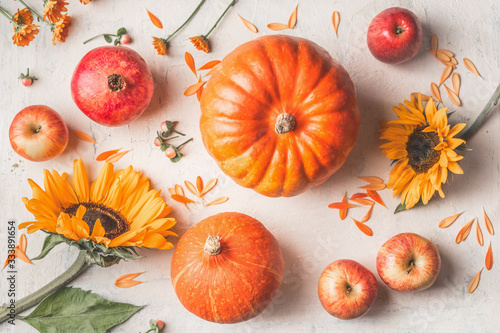 Composition made with pumpkins  sunflowers and apples on white rustic background. Top view