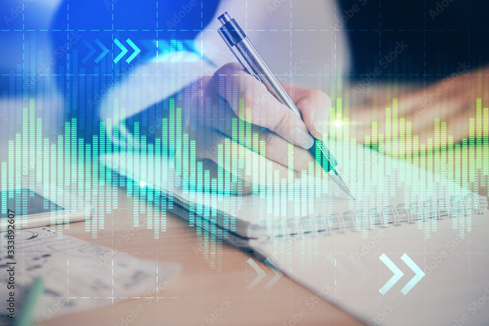 A woman hands writing information about stock market in notepad. Forex chart holograms in front. Concept of research. Multi exposure A woman hands writing information about stock market in notepad. Forex chart holograms in front. Concept of research. Multi exposure