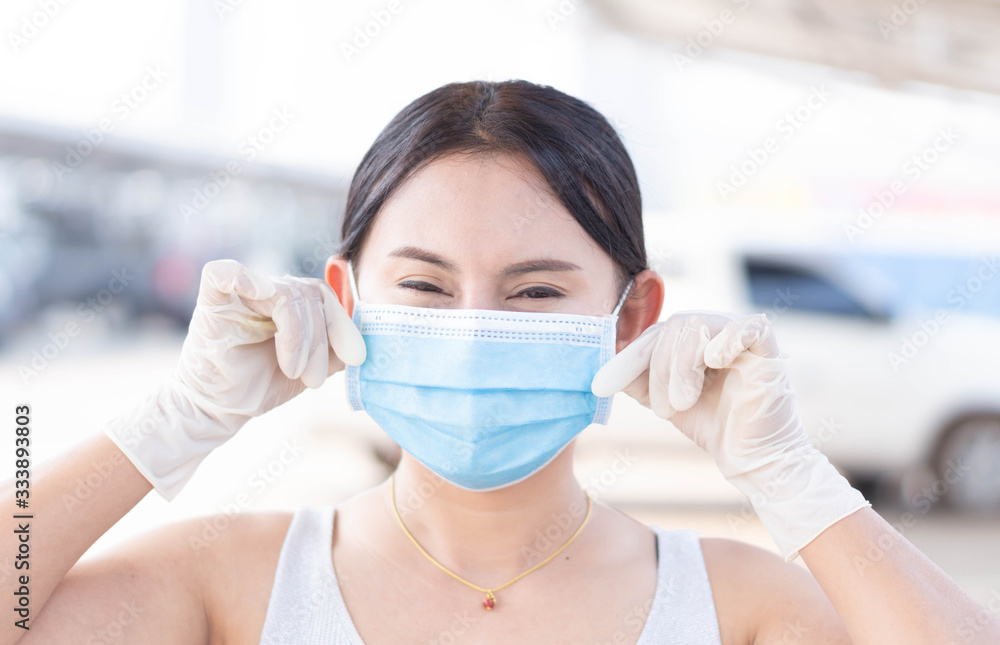 Closeup woman wearing face mask for protect air polution or virus covid 19 with white glove in car park of supper market background, health care and medical concept Closeup woman wearing face mask for protect air polution or virus covid 19 with white glove in car park of supper market background, health care and medical concept