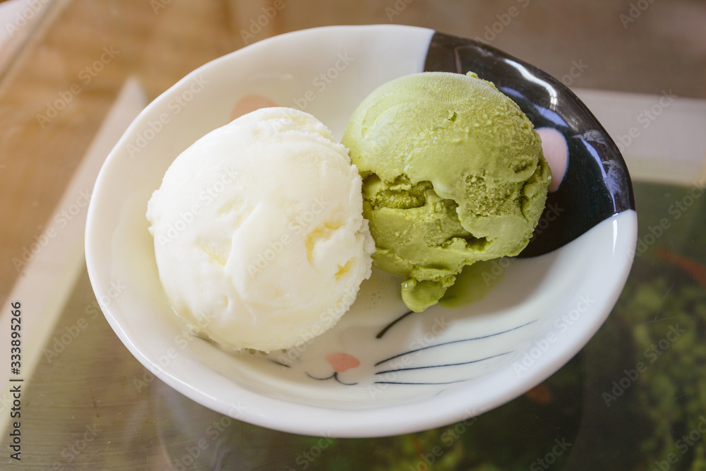Green tea matcha ice cream scoop in white bowl from top-view isolated on white background. Pistachio, coconut, milk ice cream on cat face design in a bowl Green tea matcha ice cream scoop in white bowl from top-view isolated on white background. Pistachio, coconut, milk ice cream on cat face design in a bowl