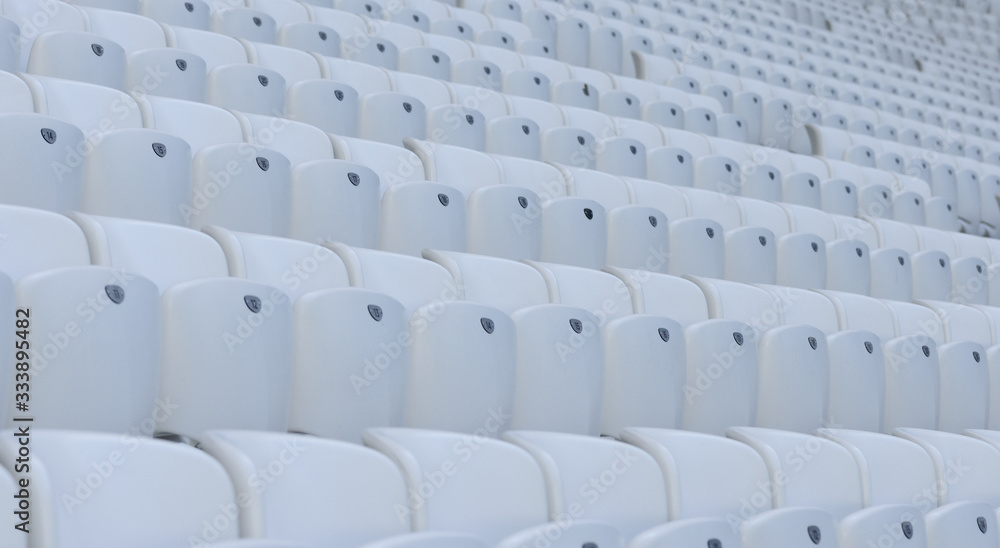 Fototapeta premium Empty white chairs at the soccer stadium during quarantine