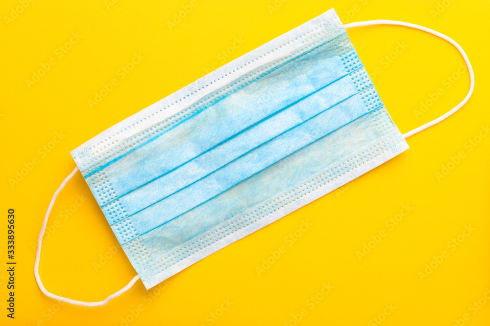 Protective medical mask on a yellow background Protective medical mask on a yellow background