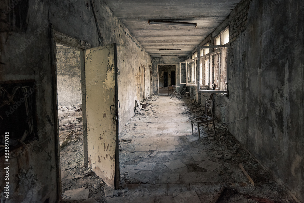 Hallway with open windows in abandoned school in Pripyat near Chernobyl in Ukraine